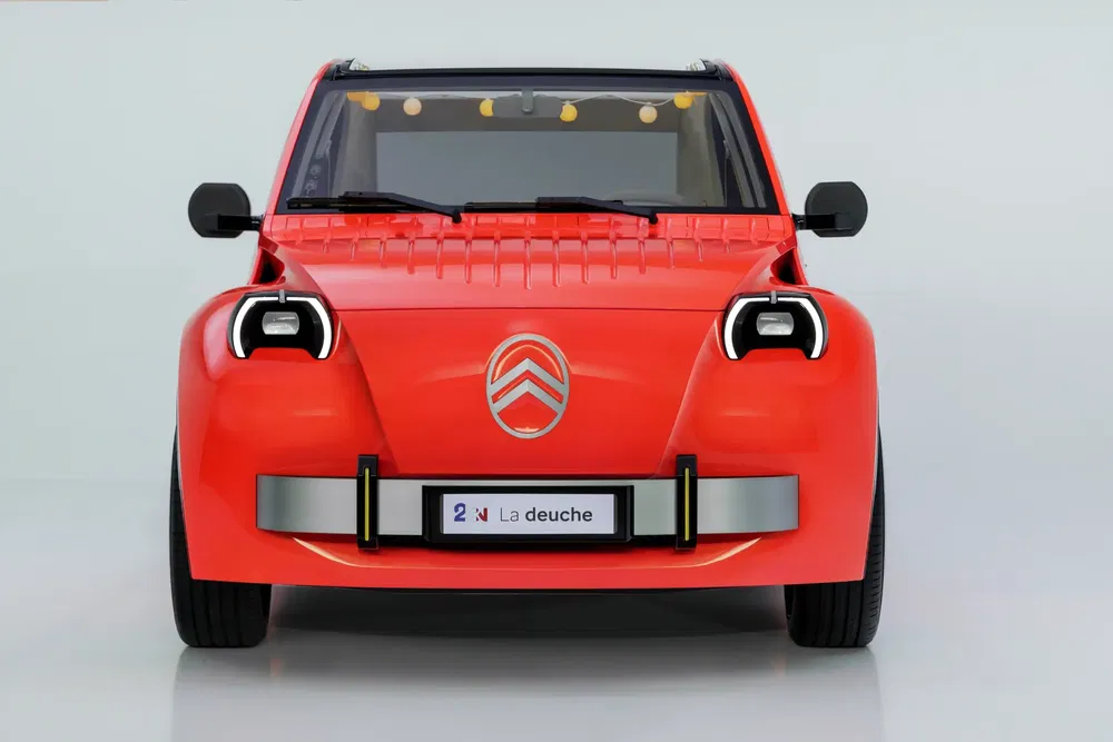 Concept-car Citroën rouge avec phare distinctif et emblème avant sur fond blanc.