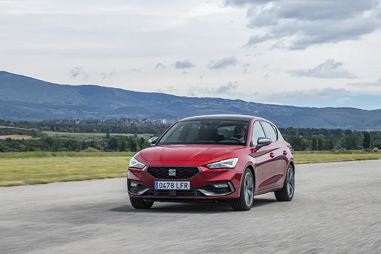 {"fr":"SEAT Leon rouge roulant sur route panoramique avec montagnes en arrière-plan.","nl":"Rode SEAT Leon rijdt op schilderachtige weg met bergen op de achtergrond."}