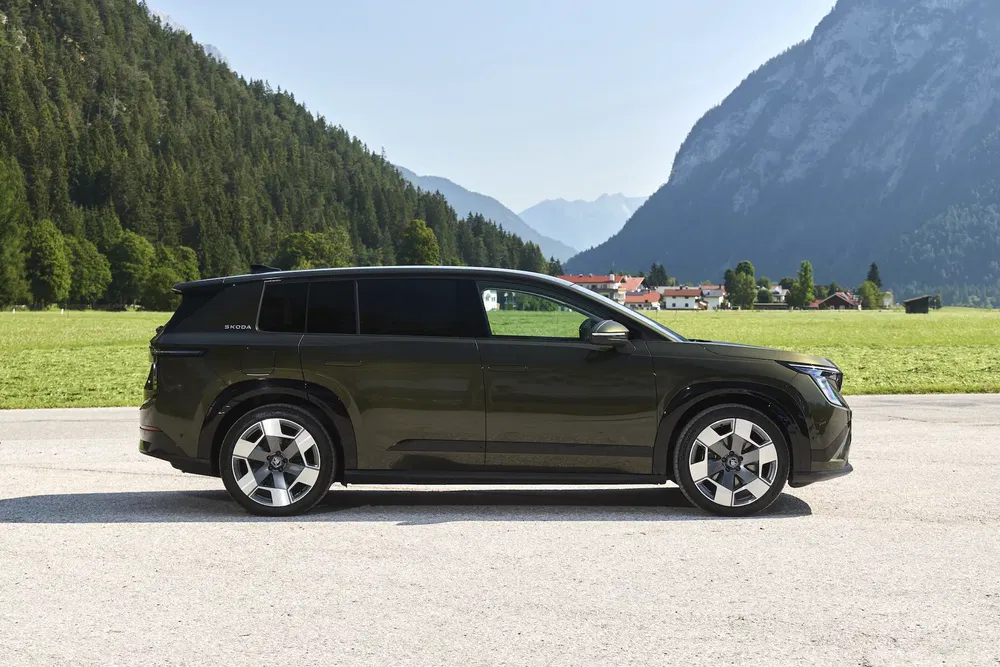 Zwarte Skoda elektrische SUV in open lucht met berglandschap op de achtergrond.