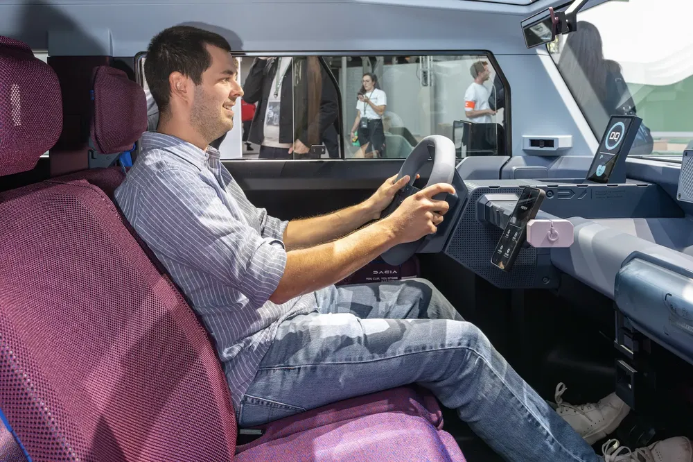 Conducteur dans l'habitacle d'une voiture Dacia, intérieur moderne et spacieux.