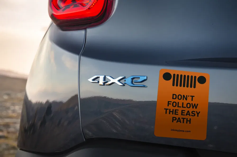 Détail arrière d'une Jeep 4xe avec autocollant motivant "Don't Follow The Easy Path".