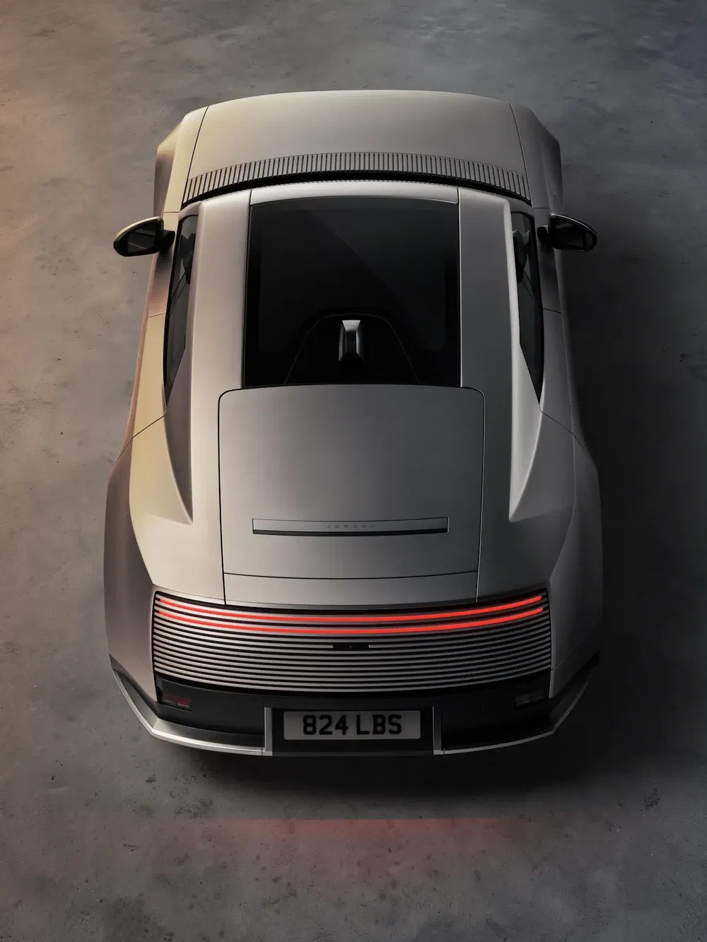 Bovenaanzicht van de moderne Porsche 911 op grijze ondergrond, achterlichten aan.