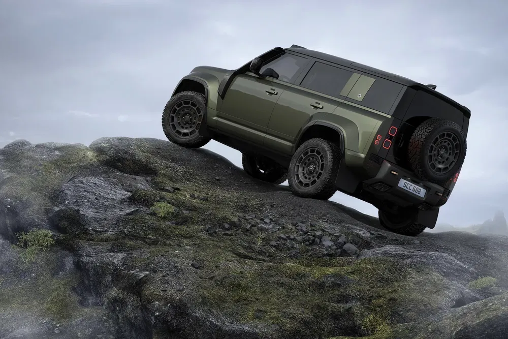 Land Rover Defender vert sur terrain rocheux, démontrant ses capacités tout-terrain impressionnantes.