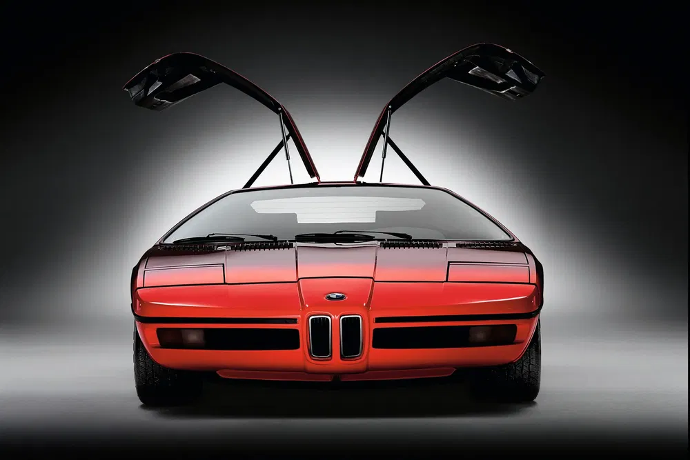 Concept BMW avec portes papillon, design avant saisissant, couleur rouge vibrante.