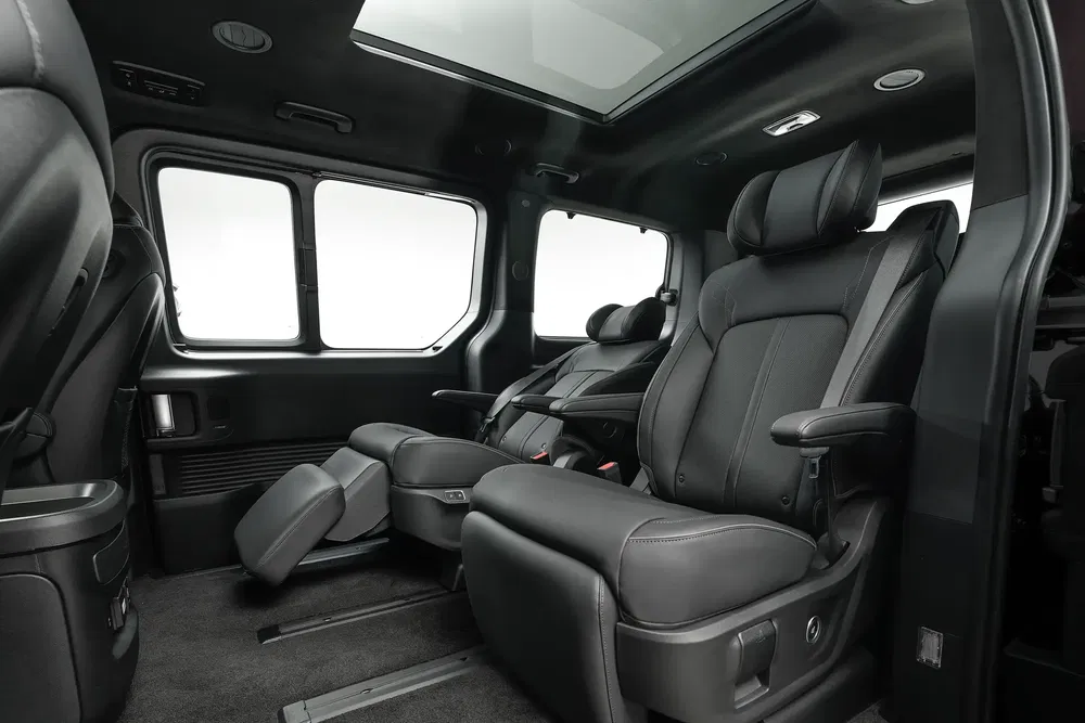 Luxe achterstoelen van de Kia Carnival met panoramisch dak, ruime en comfortabele interieur.