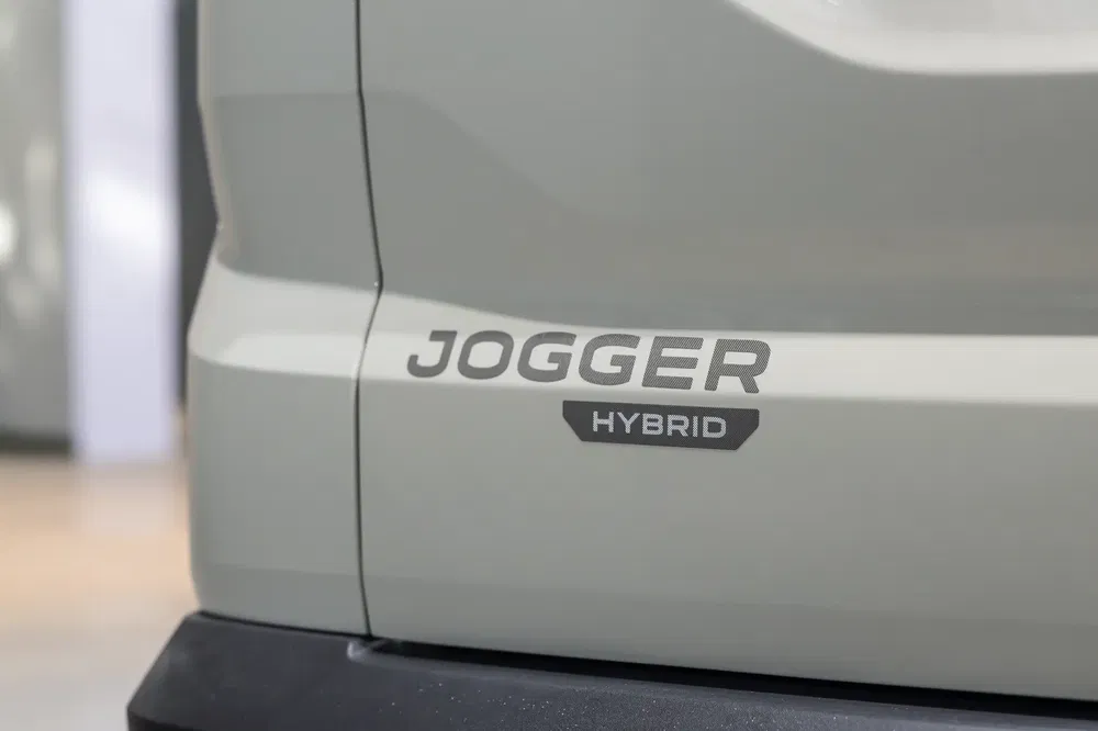 Achterkant van Dacia Jogger Hybrid, grijze carrosserie met hybride accentuering.