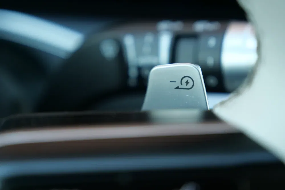 Palette de changement de vitesse avec symbole électrique sur fond de tableau de bord flou.