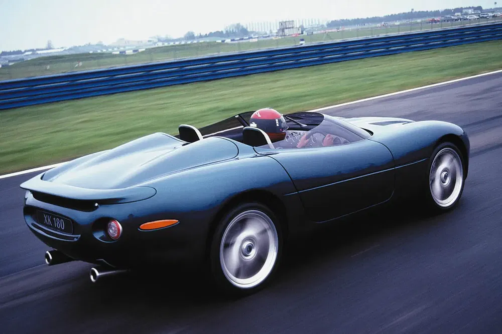 Jaguar XK180 sur circuit, design aérodynamique, performance sportive.