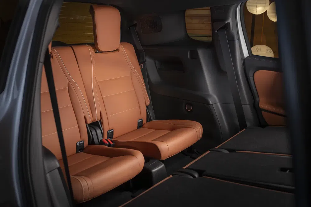 Intérieur arrière d'un SUV Toyota Highlander 2024 avec sièges en cuir marron.