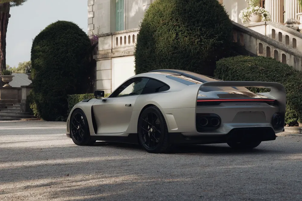 Voiture sport Project 911 MM de 1998 garée devant un manoir luxueux.