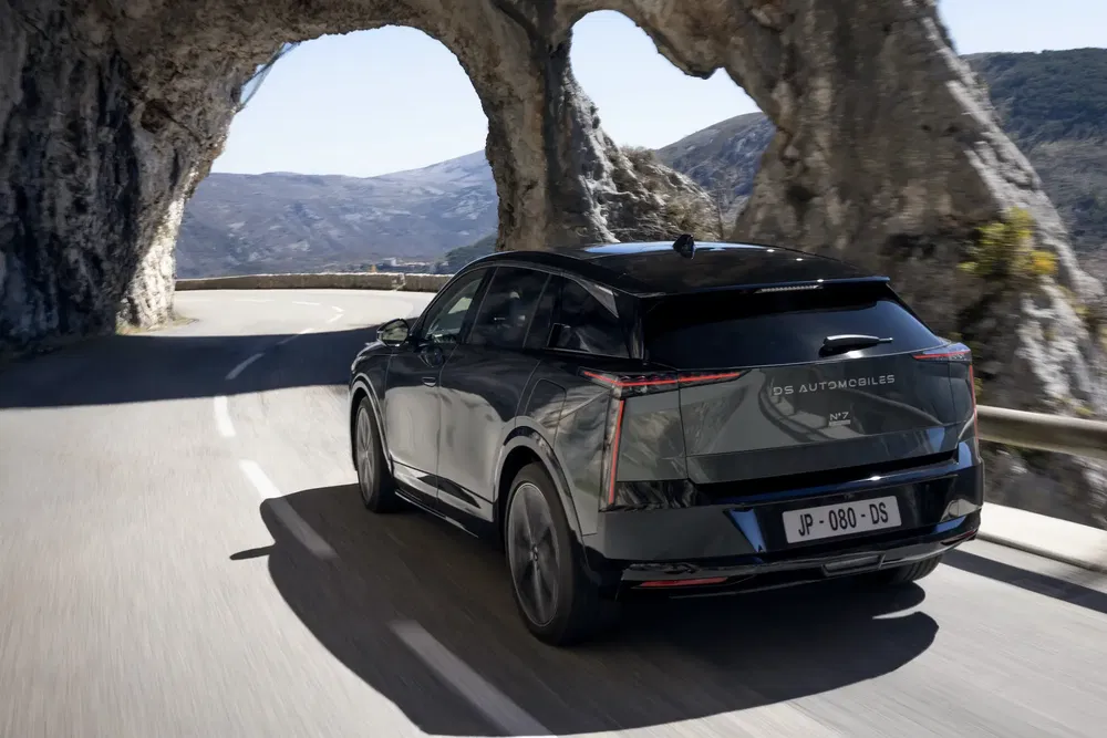 DS Automobiles DS7 SUV sur route de montagne avec tunnel rocheux.