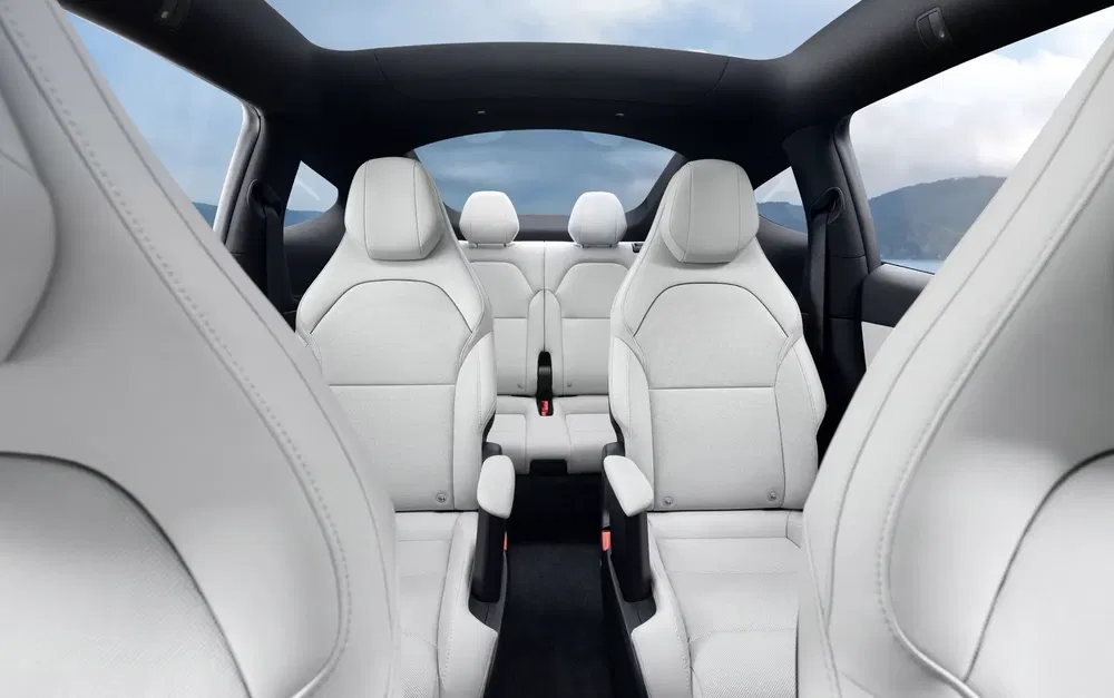 Luxe en modern interieur van een Tesla Model Y met witte lederen stoelen.