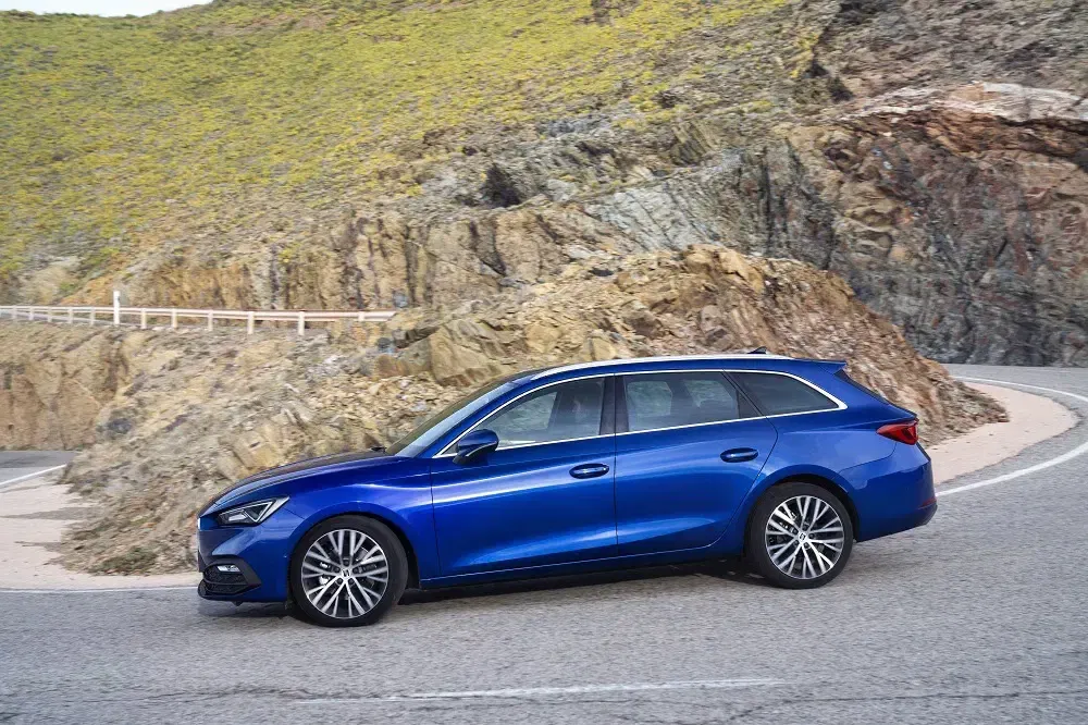 Break Seat Leon bleu vibrant sur route sinueuse devant un paysage rocheux.