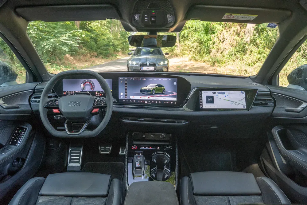 Hoogtechnologische interieur van de Audi Q8 met dubbele digitale schermen op bosweg.