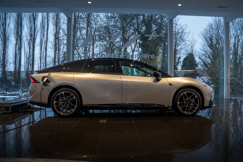 Elektrische auto Xpeng P7 aan het opladen in moderne glazen showroom.