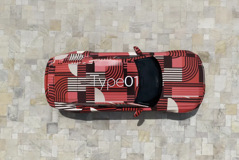 Voiture Type01 avec design géométrique rouge et noir sur surface pavée.