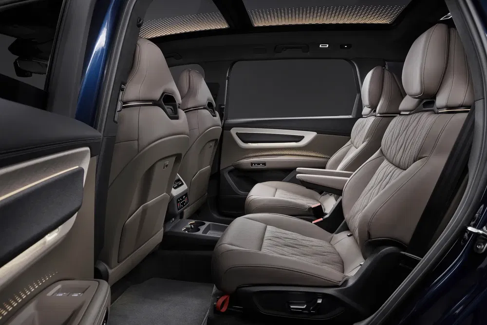 Luxe BMW SUV-interieur met beige leren stoelen en panoramisch dak.