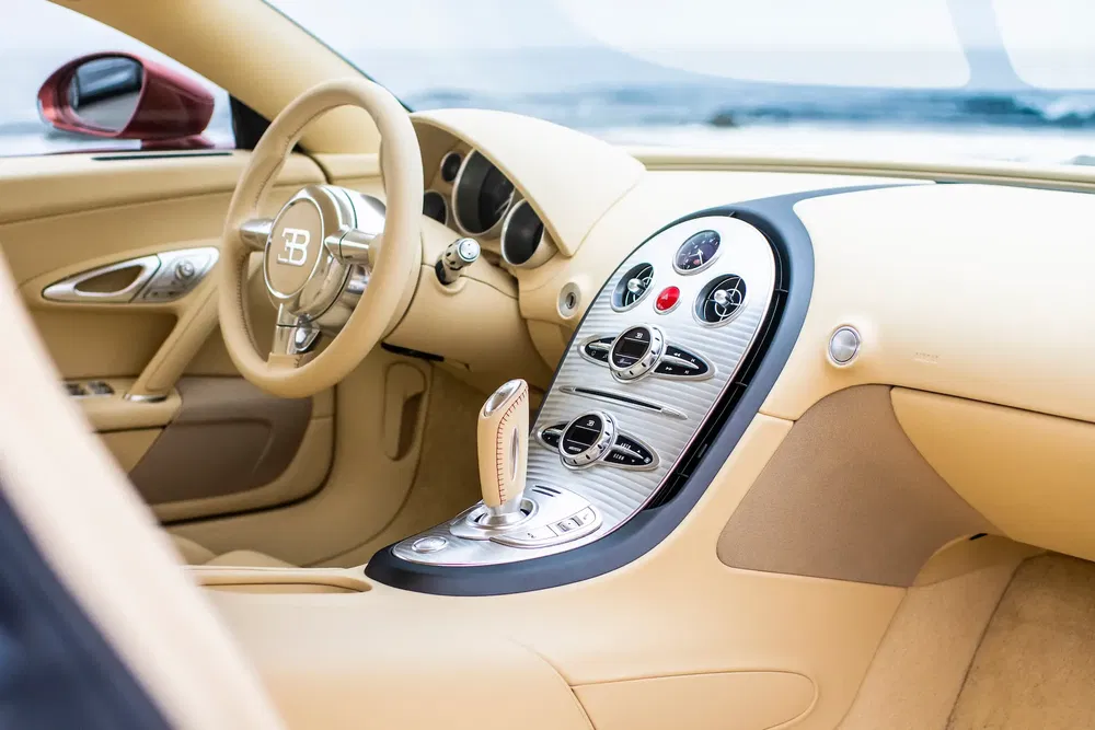 Intérieur luxueux d'une Bugatti Veyron avec volant beige et tableau de bord chromé.