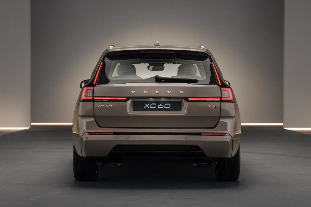 Vue arrière du Volvo XC60 T6 marron dans un studio moderne et épuré.