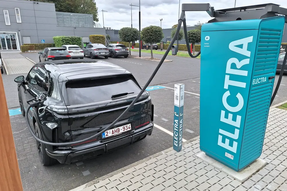 SUV électrique noir chargeant à une station Electra moderne sur un parking.