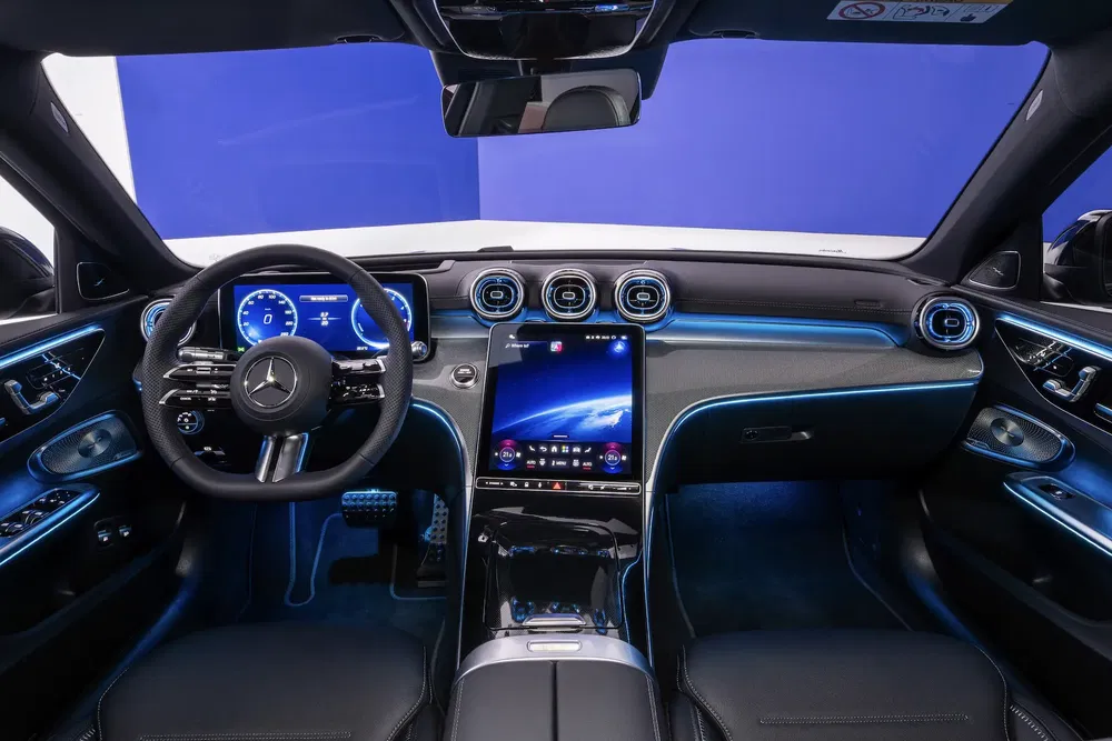 Intérieur high-tech d'une Mercedes-Benz moderne avec écran tactile central et éclairage LED bleu.