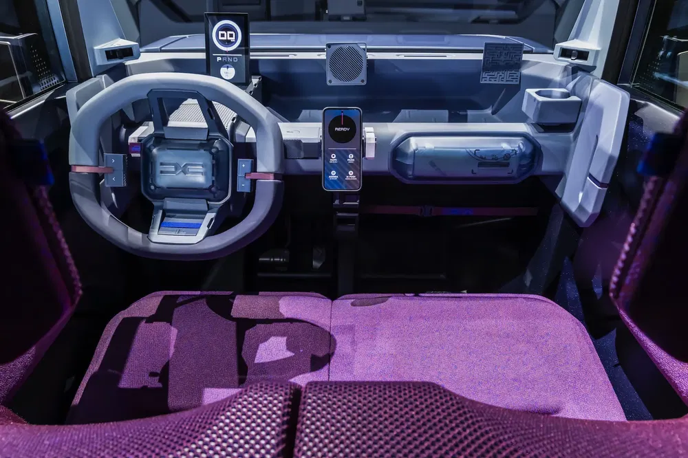 Intérieur futuriste de la Renault 4 électrique avec volant innovant et affichages numériques.