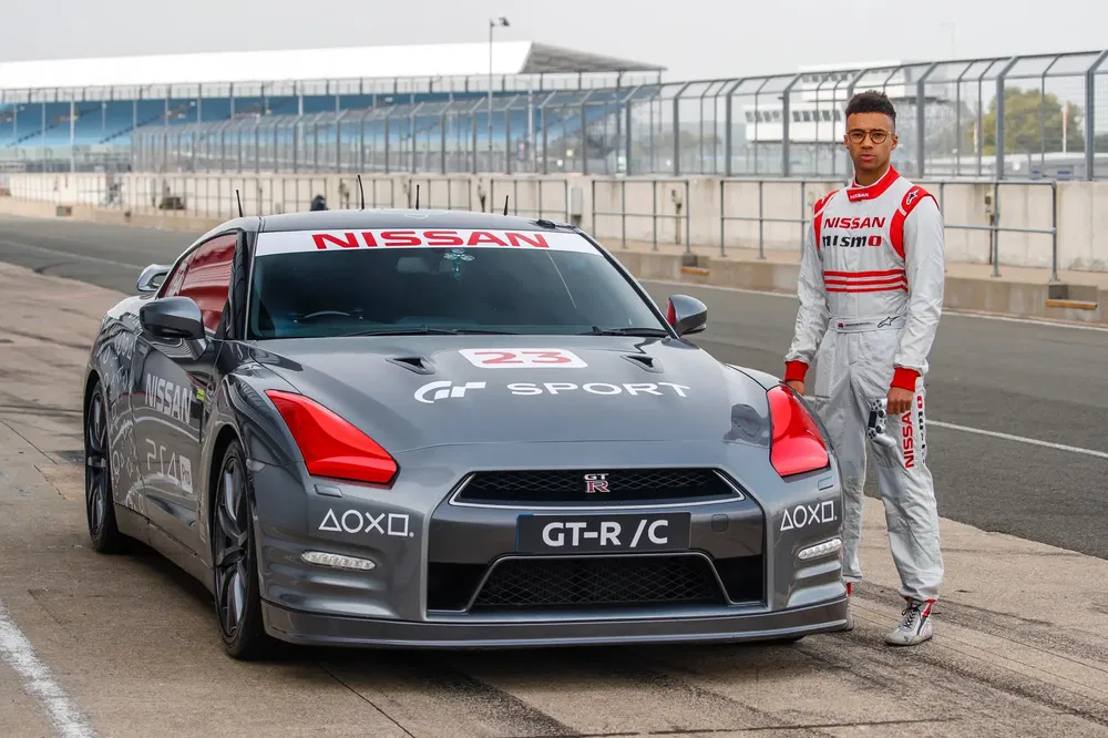 Nissan GT-R/C sur circuit avec conducteur en combinaison de course, ambiance sportive.