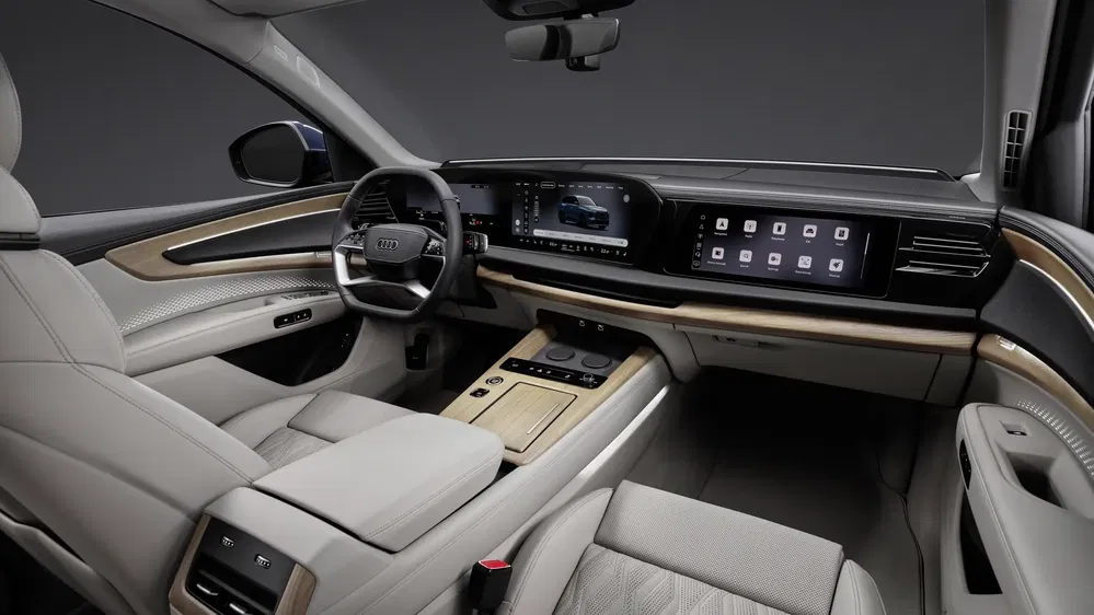 Intérieur luxueux Audi Q6 avec tableau de bord numérique et finitions en cuir beige.