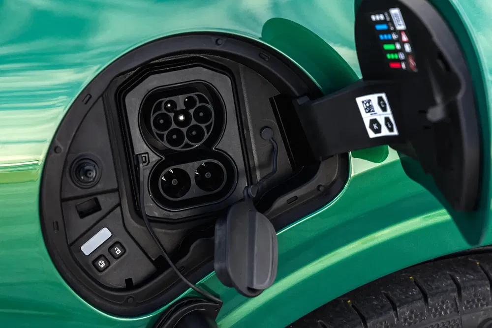 Prise de recharge électrique d'une voiture verte en gros plan.