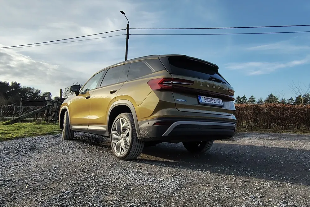SUV Skoda Kodiaq doré sur chemin de gravier par une journée ensoleillée.