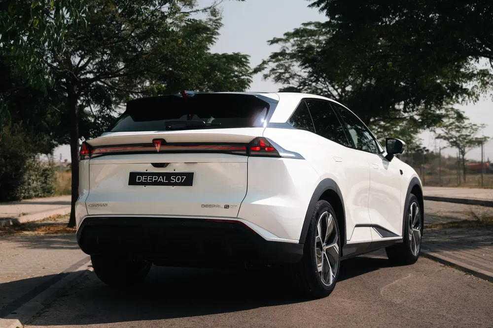 SUV électrique Deepal S07 blanc, stationné sur route avec arbres en arrière-plan.