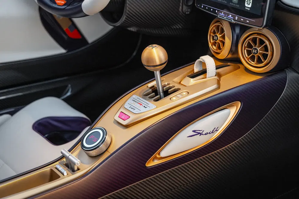 Luxe gouden auto-interieur, elegant ontwerp met modern dashboard en versnellingspook.