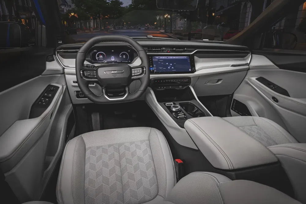 Moderne interieur van een Jeep Grand Cherokee met digitaal dashboard en luxe afwerkingen.