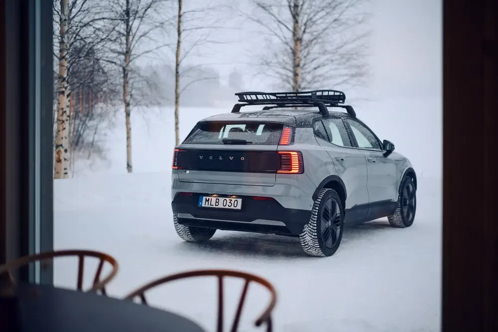Volvo SUV moderne dans la neige, équipé de pneus d'hiver et d'un porte-bagages.