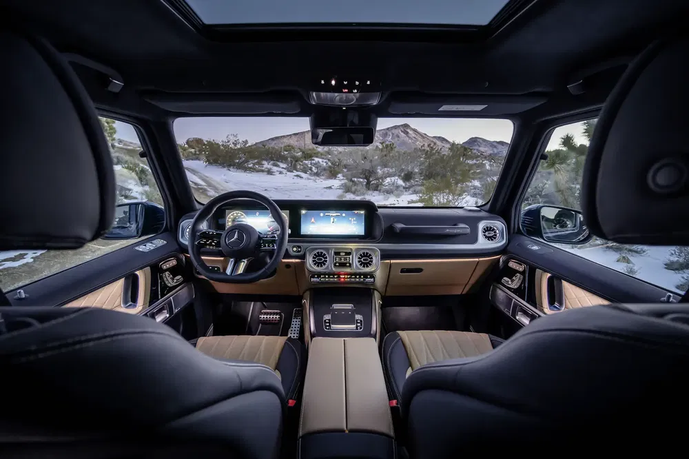 Luxe interieur van Mercedes-Benz G-Klasse, moderne digitale dashboard en stijlvolle stuurwiel.