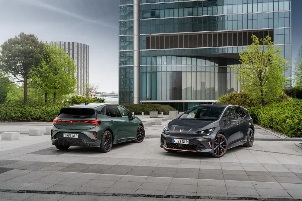 Deux voitures Cupra Born garées devant un bâtiment moderne, ambiance urbaine et contemporaine.