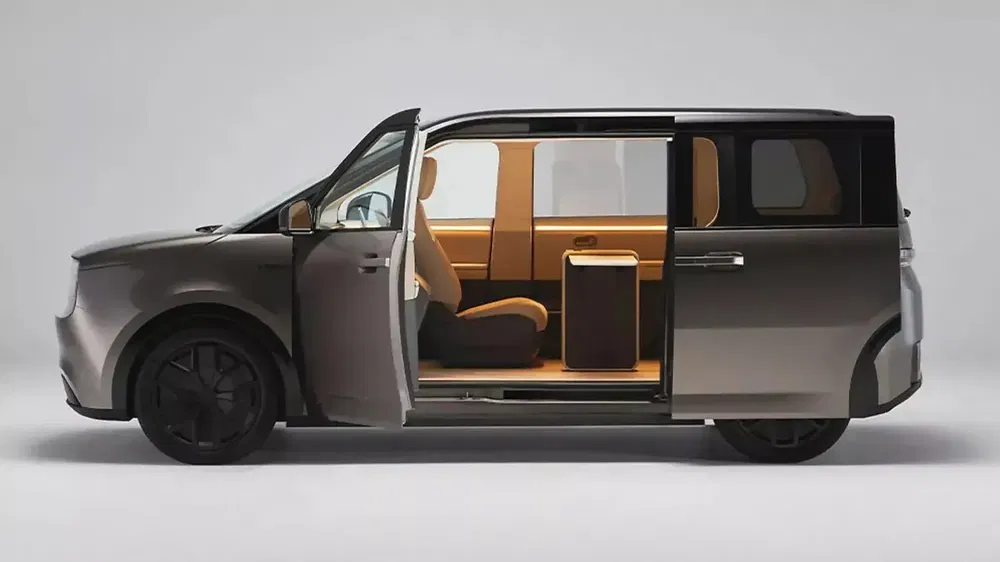 Zijaanzicht van een moderne minivan met geopende schuifdeuren en helder minimalistisch interieur.