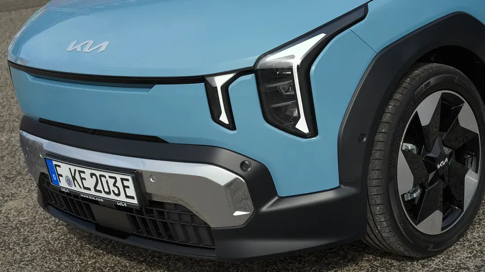 Gros plan d'une Kia électrique bleue avec phares distinctifs et plaque allemande.