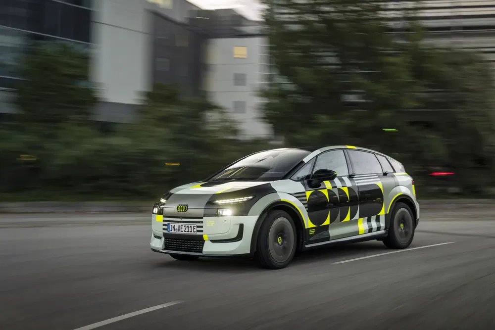 Voiture électrique Audi en mouvement, design futuriste avec motifs noirs et jaunes.