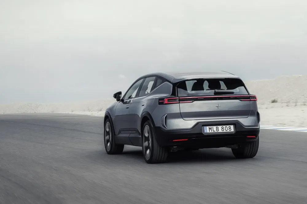Grijze Polestar 3 rijdt op een lege weg.