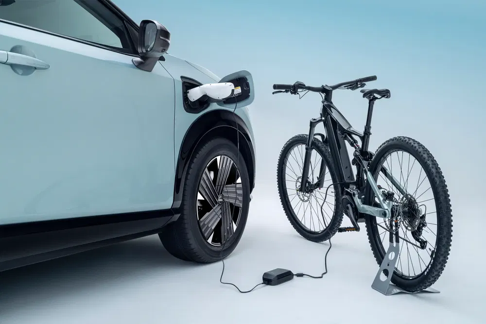 Voiture électrique rechargeant un vélo électrique, modernité et mobilité durable.