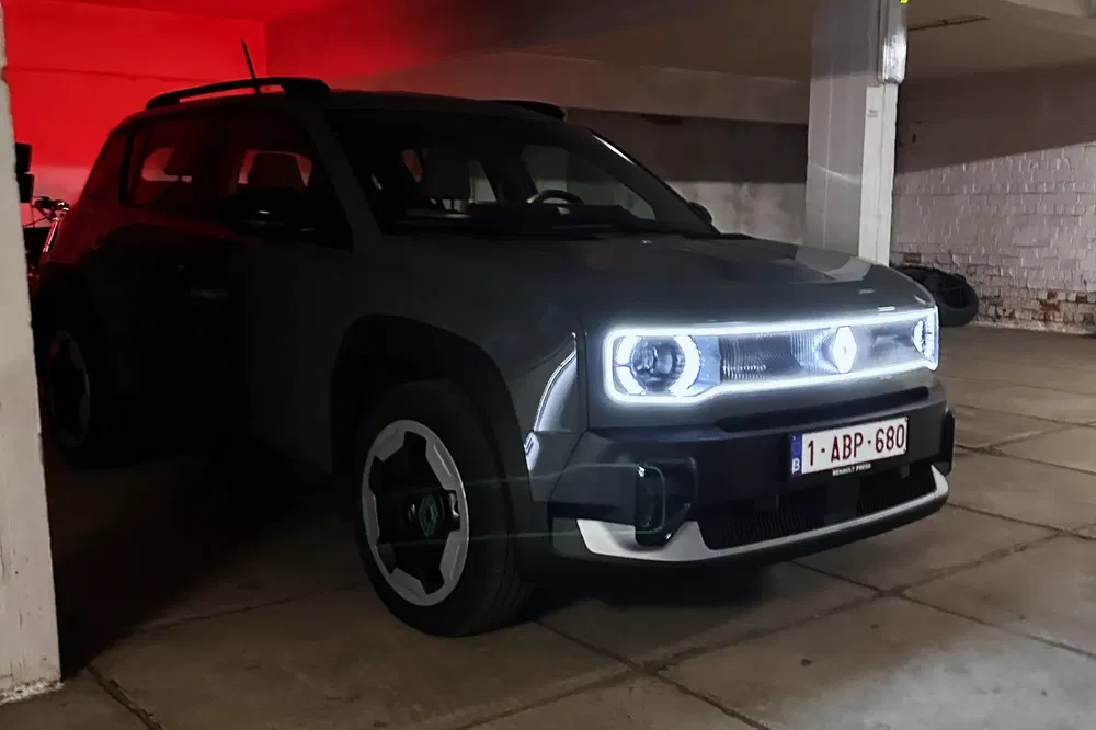 Renault Captur gris dans un parking sombre, phares LED illuminés.