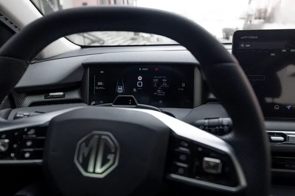 Intérieur d'une MG avec tableau de bord numérique moderne en mode 'Sport'.
