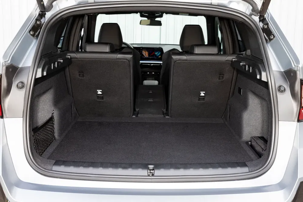 Ruime kofferbak van een elektrische SUV met neerklapbare stoelen en zichtbaar centraal scherm.