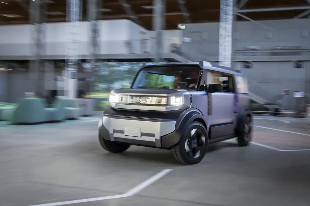 Concept car Toyota Prologue roulant dans un espace industriel moderne.