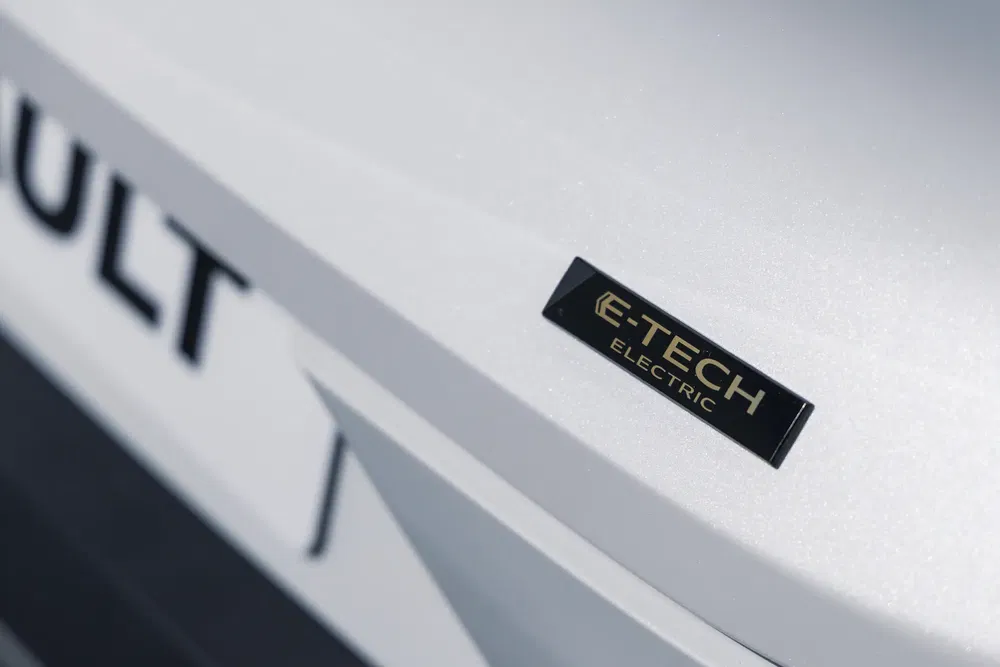 Badge E-Tech Electric sur carrosserie blanche Renault, design moderne et épuré.