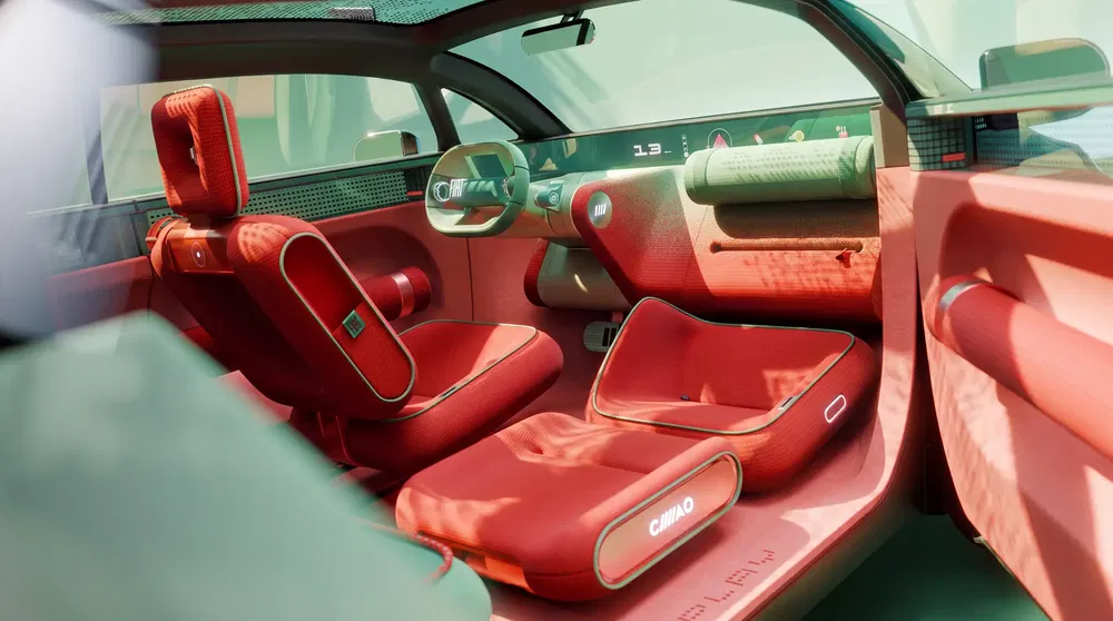 Futuristisch interieur Citroën Ami met rode stoelen en modern digitaal dashboard.