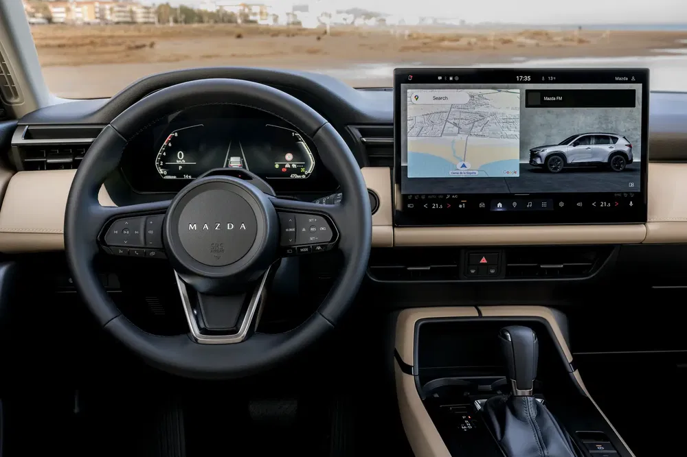 Stijlvol Mazda-interieur met leren stuur en modern touchscreen met GPS en SUV.