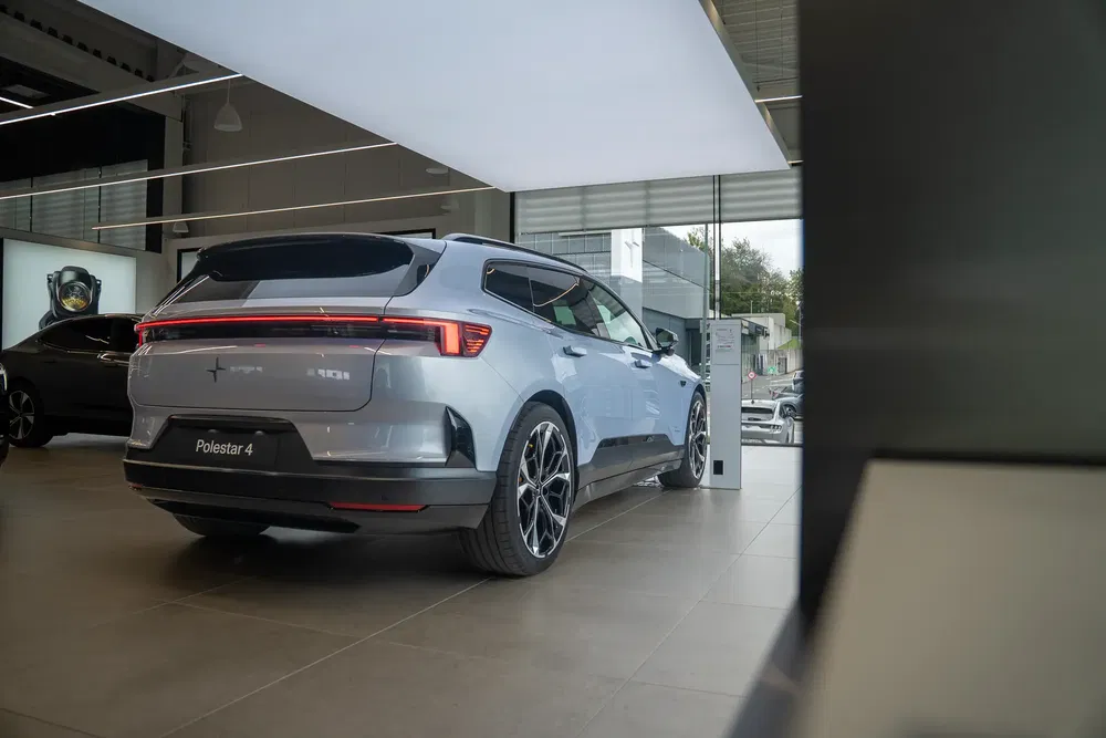 Vue arrière d'une Polestar 4 grise exposée dans un showroom moderne et bien éclairé.