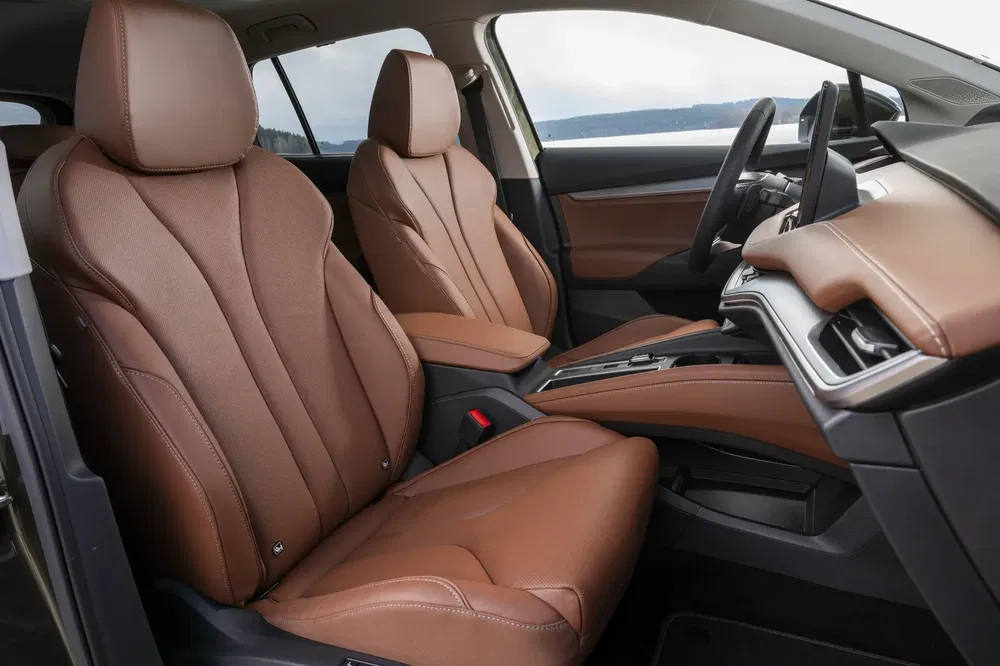 Intérieur d'une voiture avec sièges en cuir marron et tableau de bord moderne.